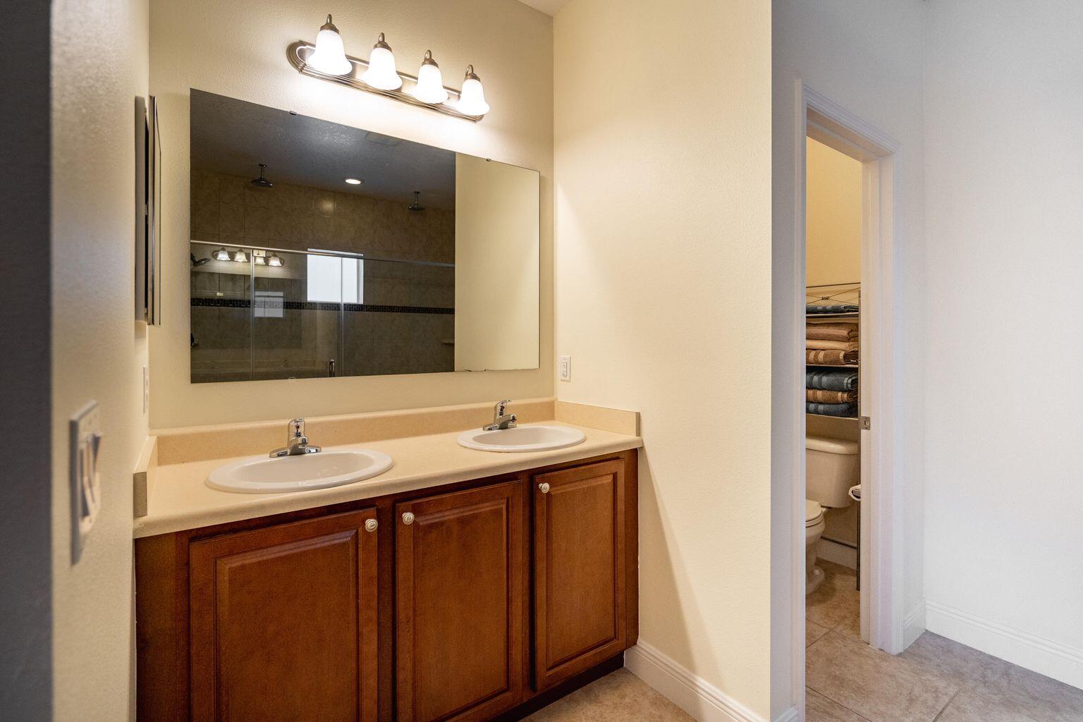 1026 Southwest Ingrassina Avenue Port St. Lucie, FL 34953 - Photo 14 of 20 a bathroom with a double vanity sink and a mirror