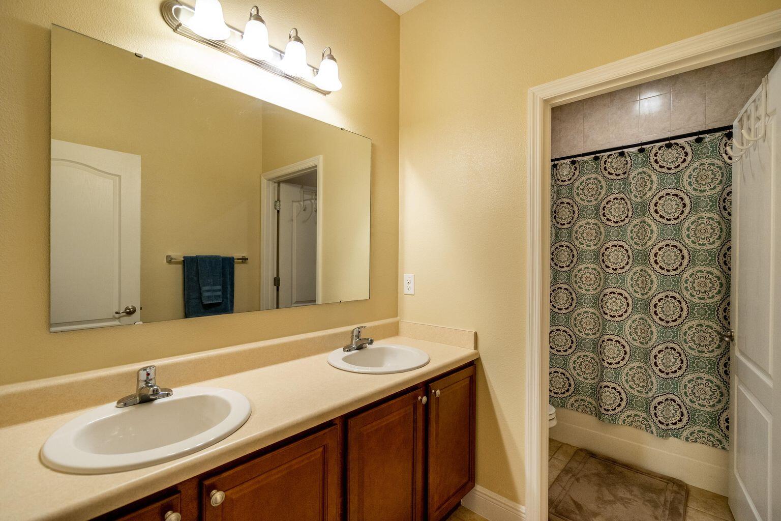 1026 Southwest Ingrassina Avenue Port St. Lucie, FL 34953 - Photo 18 of 20 a bathroom with a sink and a mirror