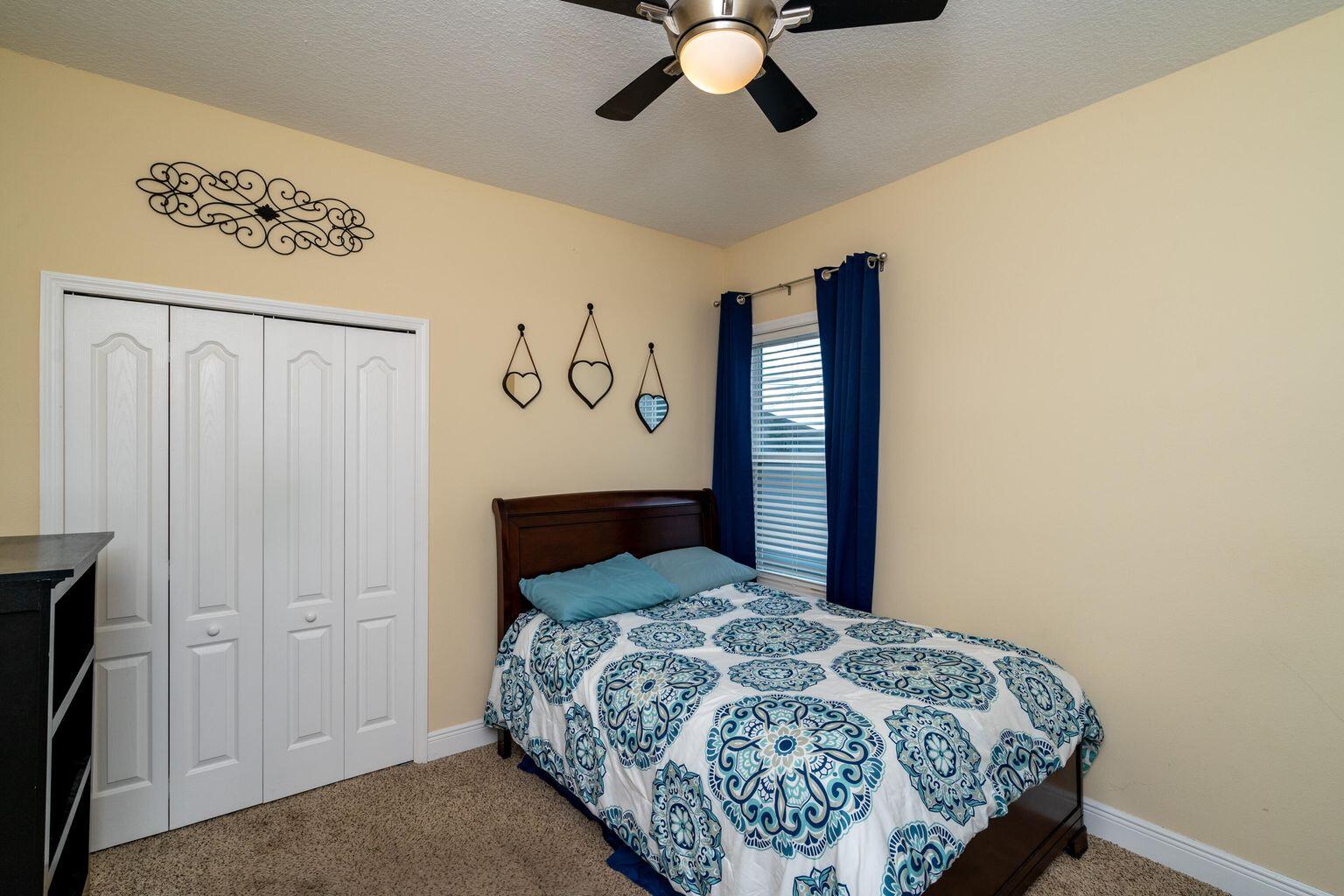 1026 Southwest Ingrassina Avenue Port St. Lucie, FL 34953 - Photo 19 of 20 a bedroom with a bed and a painting on the wall