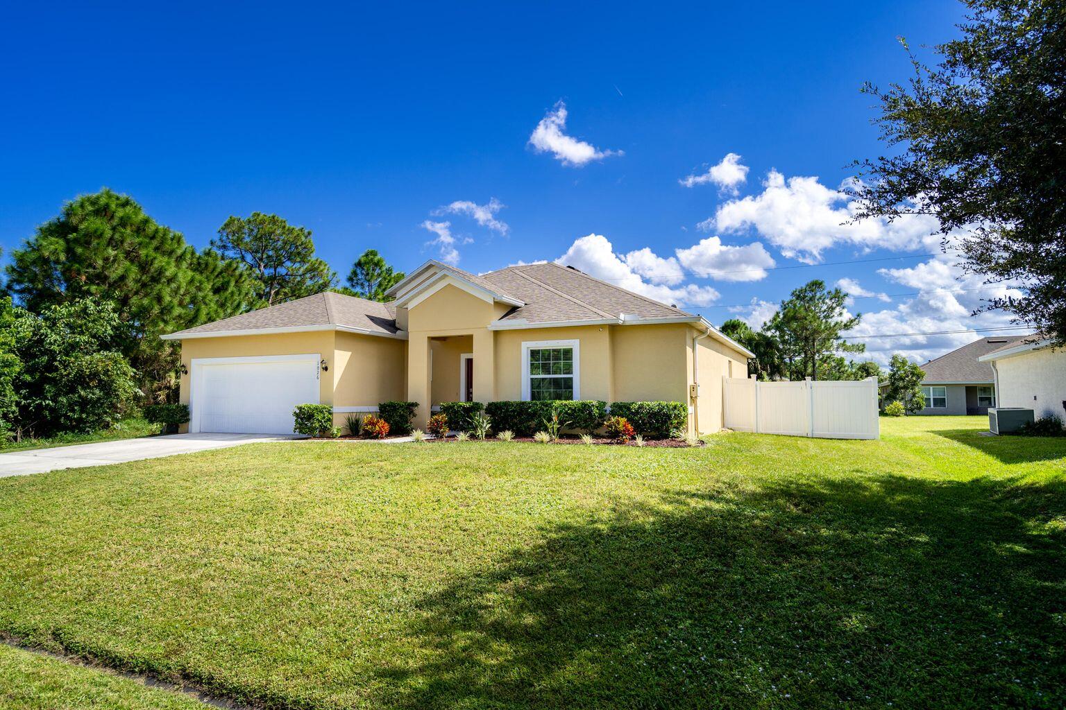 1026 Southwest Ingrassina Avenue Port St. Lucie, FL 34953 - Photo 2 of 20 a front view of a house with yard and garage