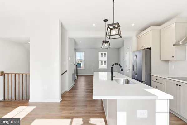 a kitchen with stainless steel appliances a table chairs and wooden floor