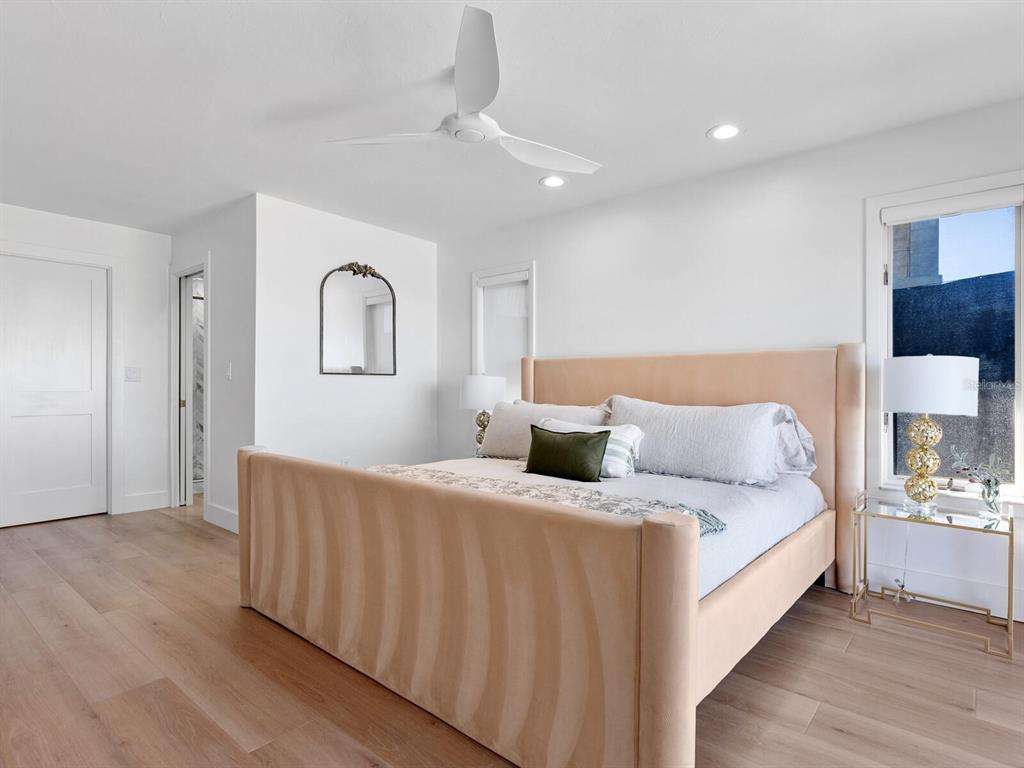 3743 Casey Key Road Nokomis, FL 34275 - Photo 17 of 36 a spacious bedroom with a bed and a lamp