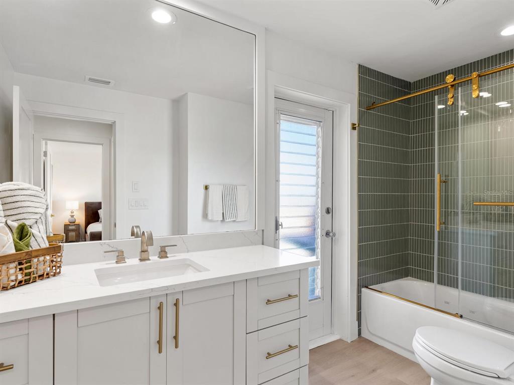 3743 Casey Key Road Nokomis, FL 34275 - Photo 18 of 36 a bathroom with a bathtub shower sink and toilet