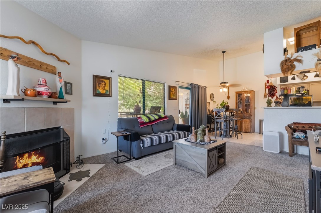 1575 West Warm Springs Road, Unit 2822 Henderson, NV 89014 - Photo 6 of 37 Living room with a textured ceiling, carpet floors, ceiling fan, and a fireplace