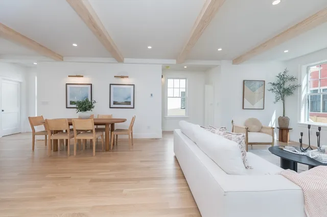 a living room with furniture wooden floor and dining table