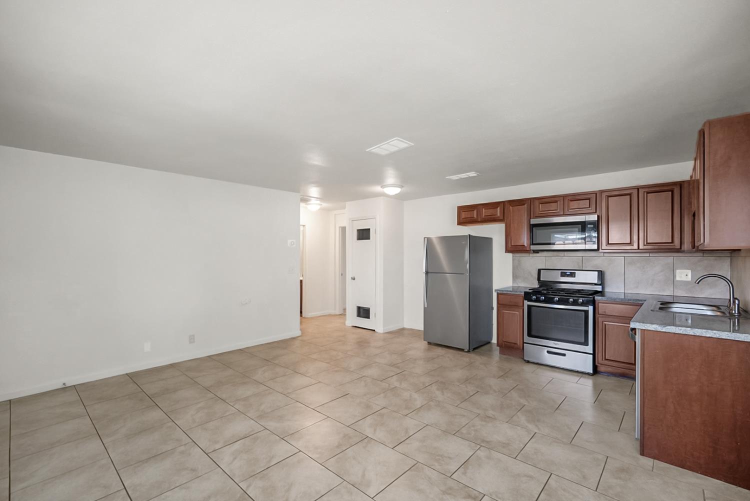 72 East 12th Street Merced, CA 95341 - Photo 11 of 13 a view of a kitchen with refrigerator stove and cabinets