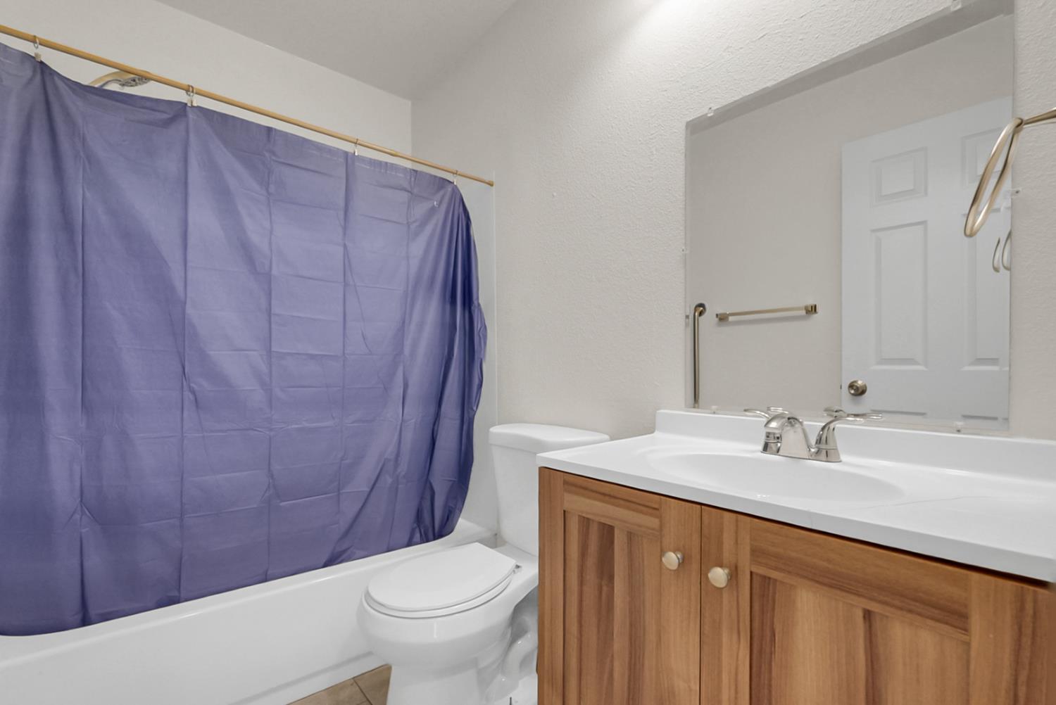 72 East 12th Street Merced, CA 95341 - Photo 13 of 13 a bathroom with a sink a toilet and shower curtain