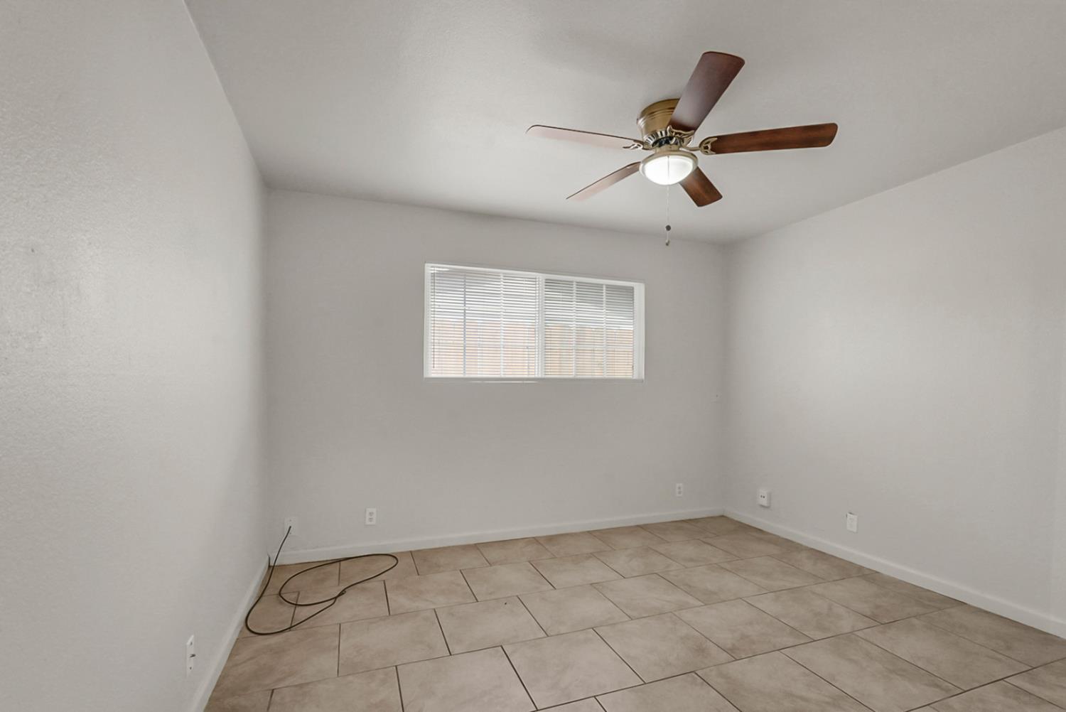 72 East 12th Street Merced, CA 95341 - Photo 7 of 13 an empty room with windows and fan