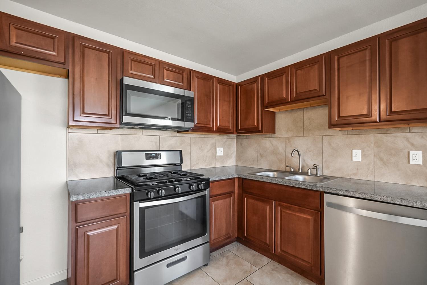 72 East 12th Street Merced, CA 95341 - Photo 10 of 13 a kitchen with granite countertop cabinets stainless steel appliances and a sink
