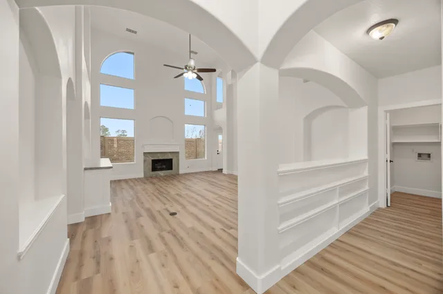 an empty room with a window and a ceiling fan