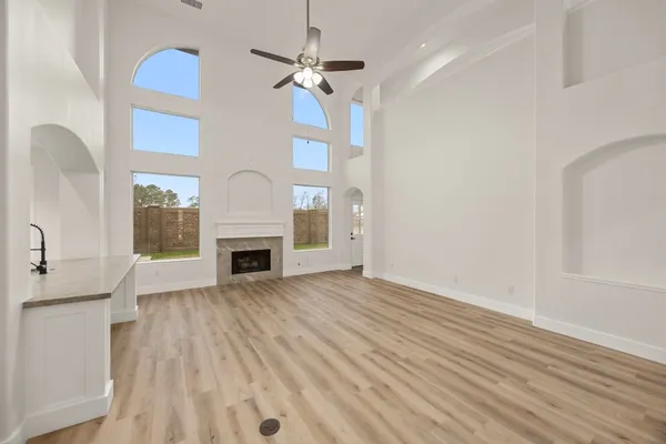 a view of a livingroom with a fireplace a chandelier and wooden floor