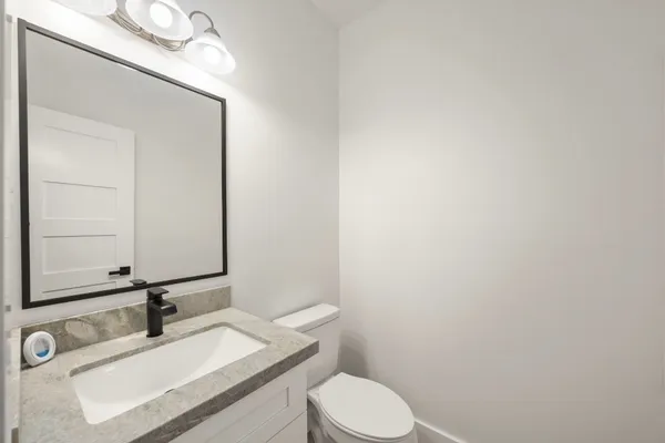 a bathroom with a sink vanity mirror and toilet
