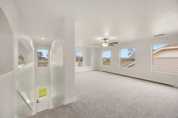 en empty room with windows and brick walls