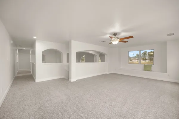 an empty room with a window and a fan