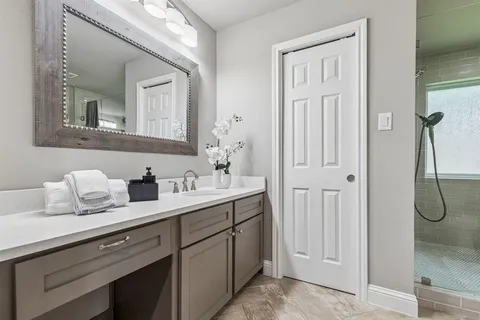 a en suite bathroom with a granite countertop sink and a mirror