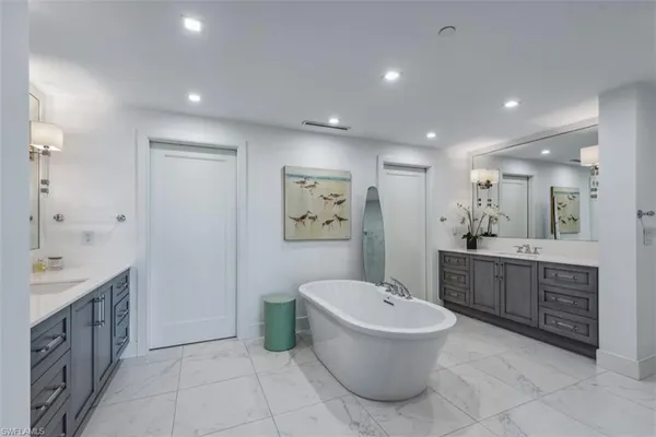 a bathroom with a bathtub shower sink and mirror