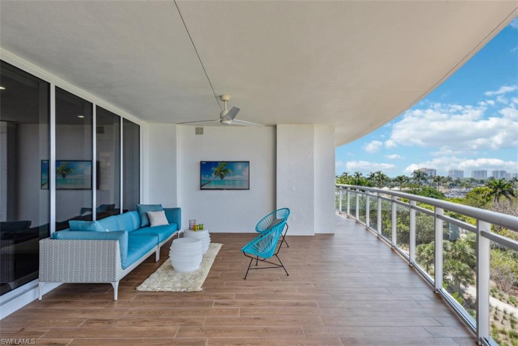 13915 Old Coast Road, Unit 504 Naples, FL 34110 - Photo 3 of 41 a balcony with furniture and a wooden floor