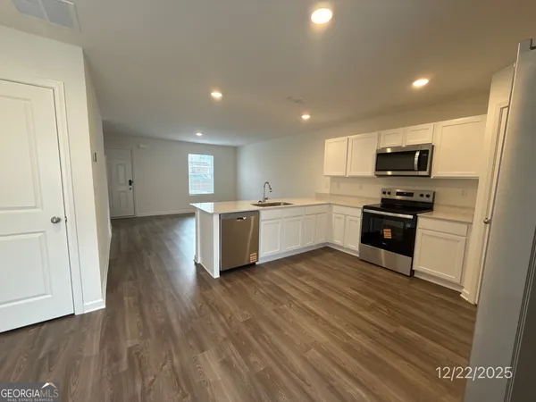 a kitchen with a refrigerator and a stove top oven