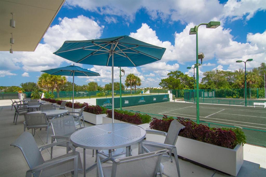 240 Sands Point Road, Unit 4104 Longboat Key, FL 34228 - Photo 42 of 47 a view of a patio with a table and chairs under an umbrella