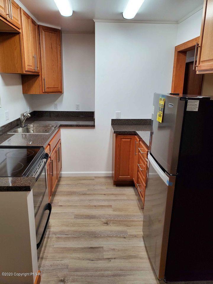 1615 Silver Maple Road Effort, PA 18330 - Photo 8 of 13 a kitchen with granite countertop a refrigerator a sink and wooden cabinets