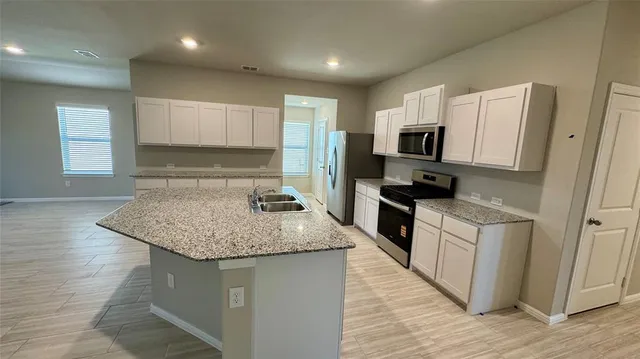 a kitchen with stainless steel appliances granite countertop a sink dishwasher a refrigerator and a stove