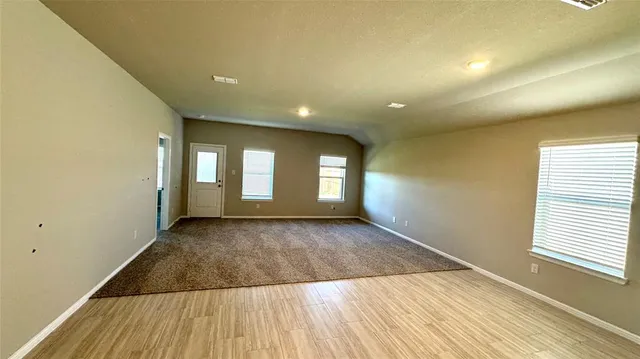 a view of open kitchen with wooden floor and refrigerator