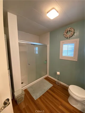 a view of a room with wooden floor and bathroom