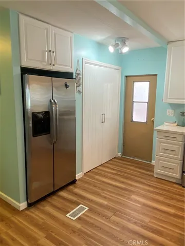 a bedroom with a bed and a refrigerator