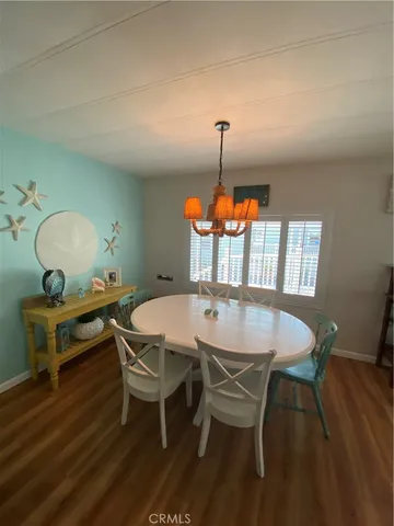 a dining room with furniture wooden floor a rug and a chandelier