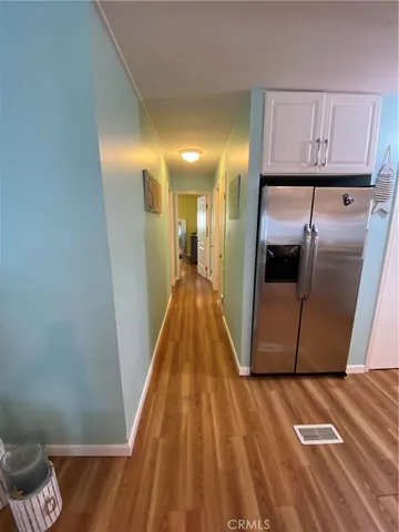 a view of a refrigerator in kitchen and wooden floor