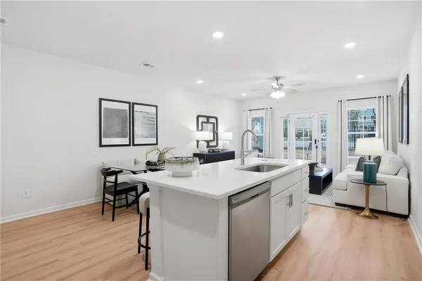 a large white kitchen with a sink table and chairs