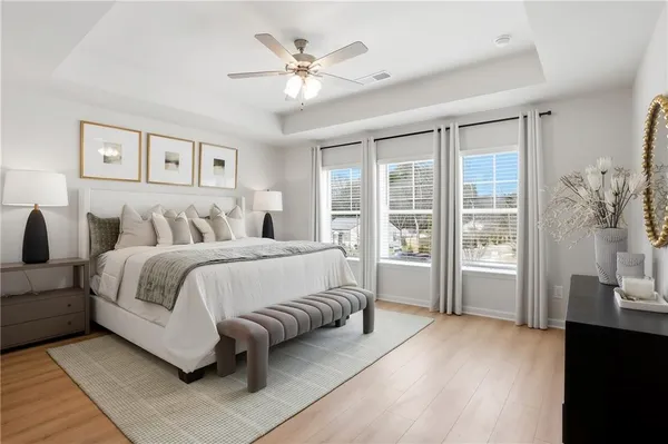 a spacious bedroom with a large bed and a chandelier