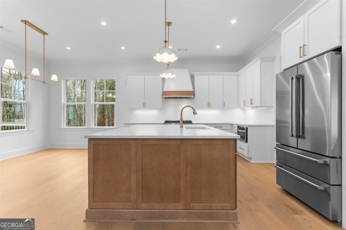 103 Mags Path Eatonton, GA 31024 - Photo 16 of 66 a kitchen with stainless steel appliances granite countertop a refrigerator a sink dishwasher a oven and a large window with wooden floor
