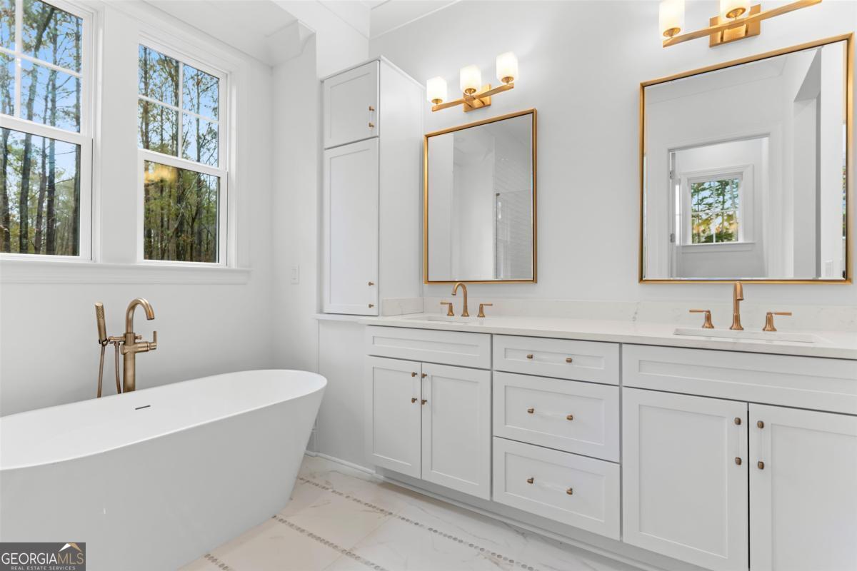 103 Mags Path Eatonton, GA 31024 - Photo 32 of 66 a bathroom with double vanity sinks a mirror and a bathtub