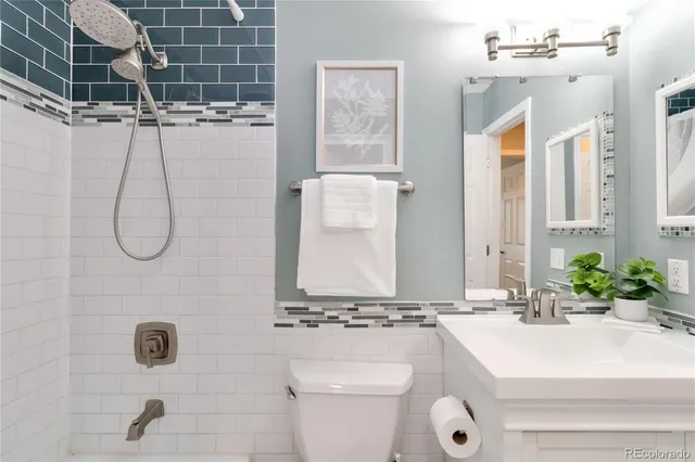 a bathroom with a sink and mirror with bathtub
