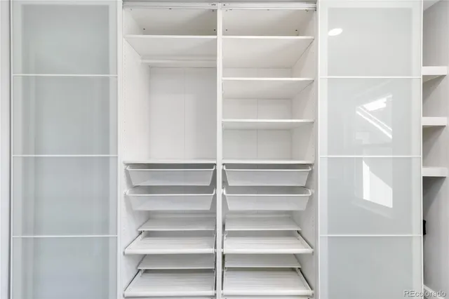 a view of walk in closet with empty racks