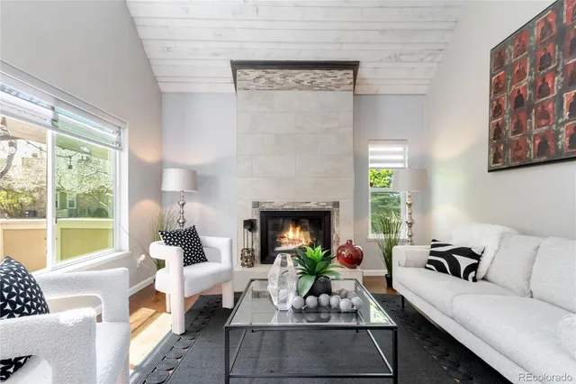 a living room with furniture a fireplace and a floor to ceiling window