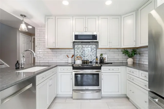 a kitchen with white cabinets stainless steel appliances and sink