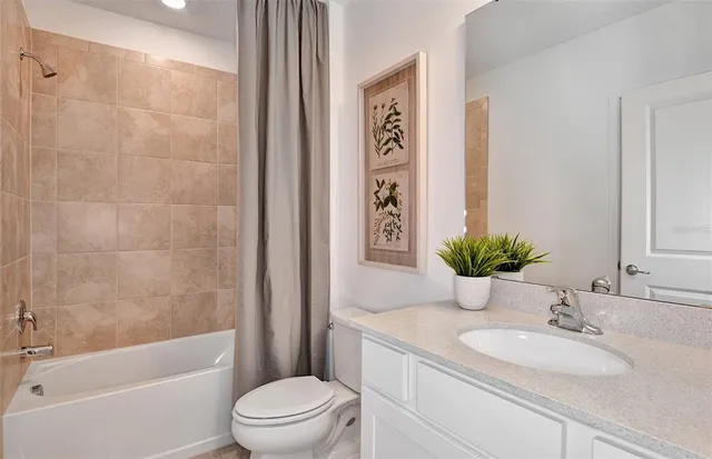 a bathroom with a granite countertop sink a toilet a mirror a vanity and shower