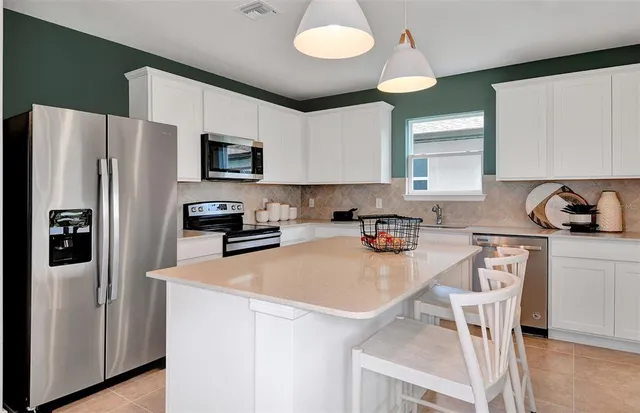 a kitchen with stainless steel appliances granite countertop a refrigerator a stove a sink and a refrigerator