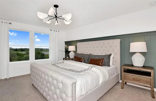 a bedroom with a bed chandelier and window