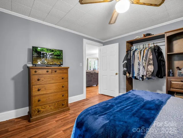 a spacious bedroom with a bed and a flat screen tv