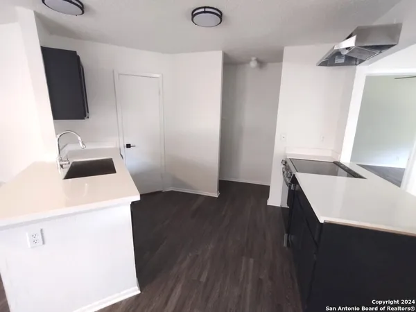 a kitchen with a sink and wooden floor