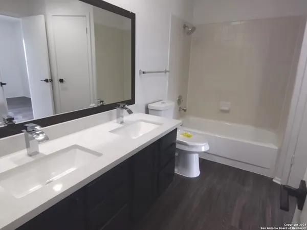 a bathroom with a double vanity sink toilet and a bathtub