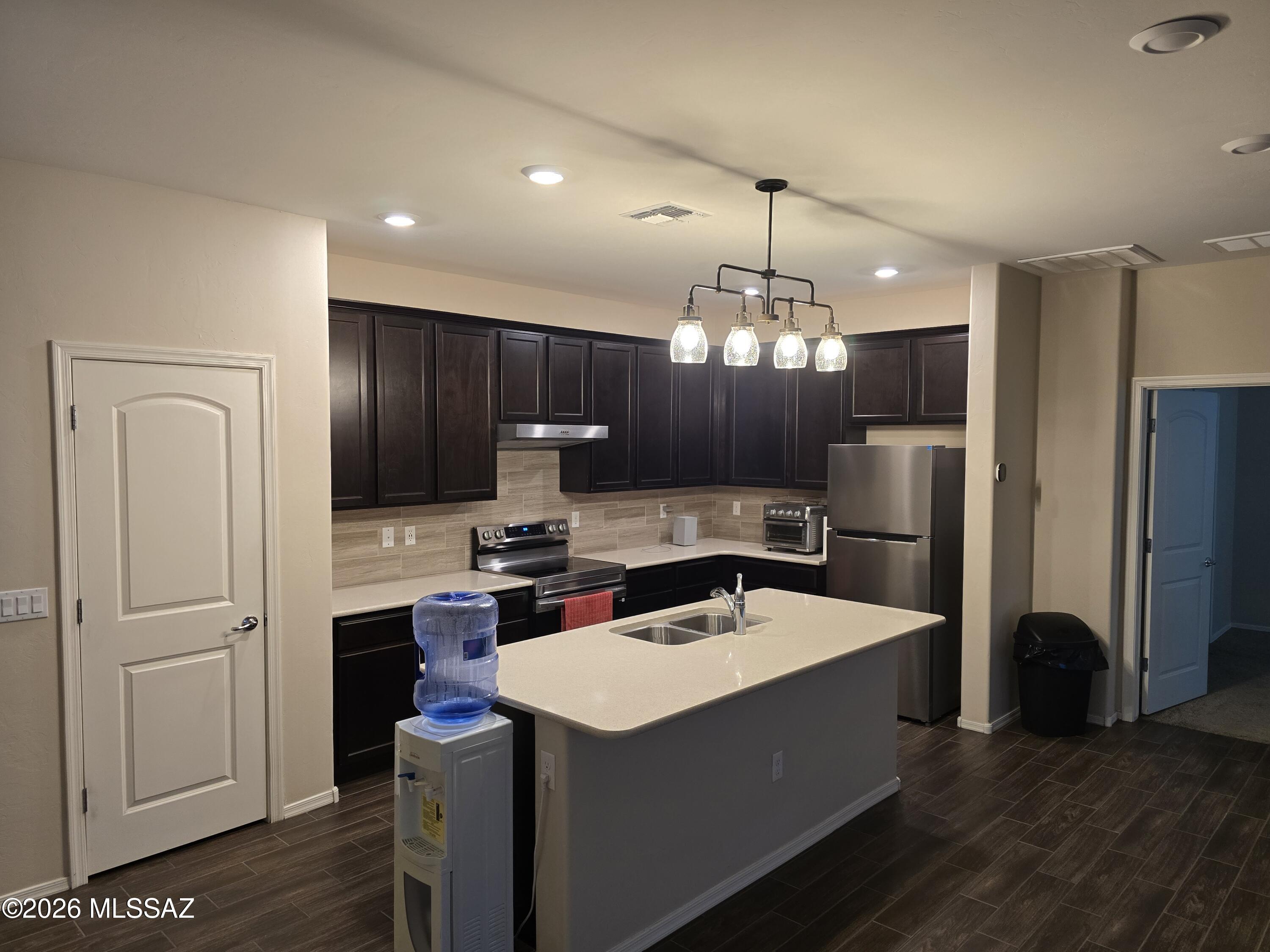 6151 South Antrim Loop Tucson, AZ 85706 - Photo 3 of 13 a kitchen that has a lot of cabinets and wooden floor