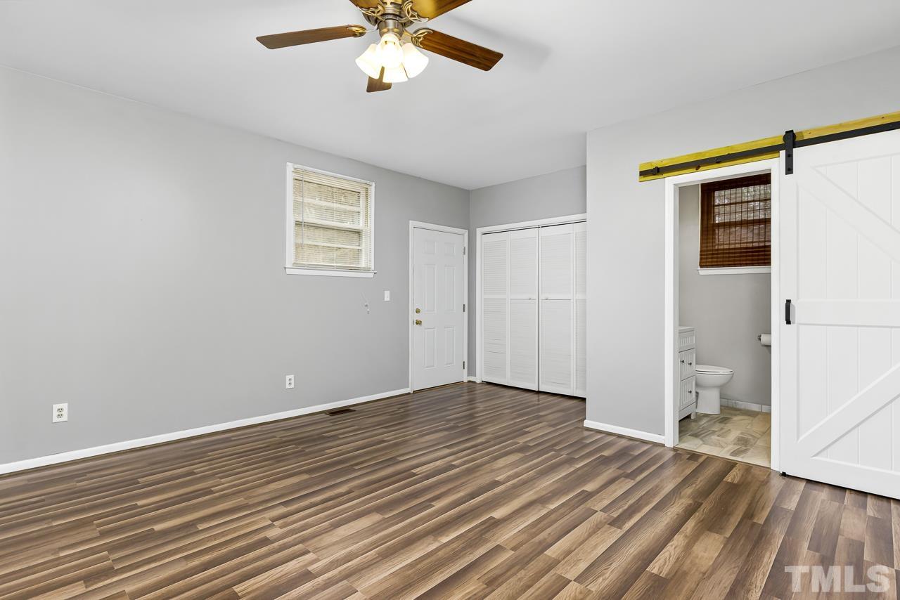 1314 Dowling Road Raleigh, NC 27610 - Photo 13 of 34 a view of an empty room with wooden floor and a ceiling fan
