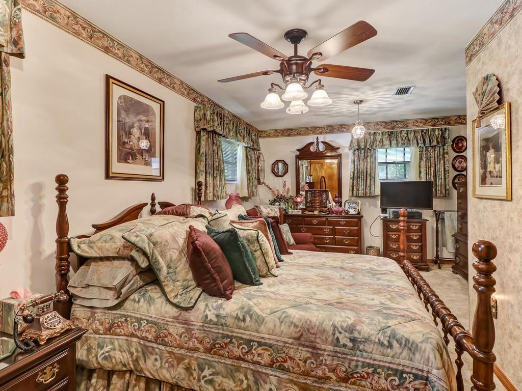 542233 Lem Turner Road Callahan, FL 32011 - Photo 7 of 31 a bedroom with a large bed and a chandelier