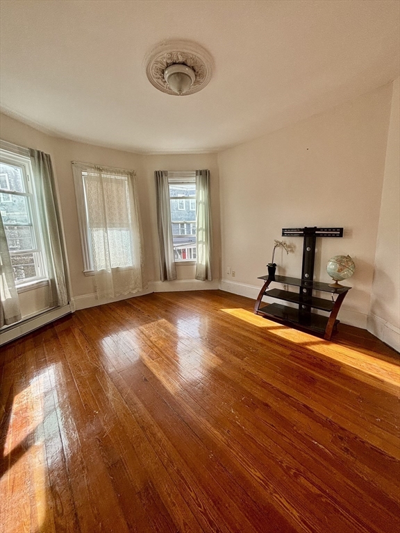 11 Raven Street, Unit 2 Boston, MA 02125 - Photo 2 of 10 a view of empty room with wooden floor and fan