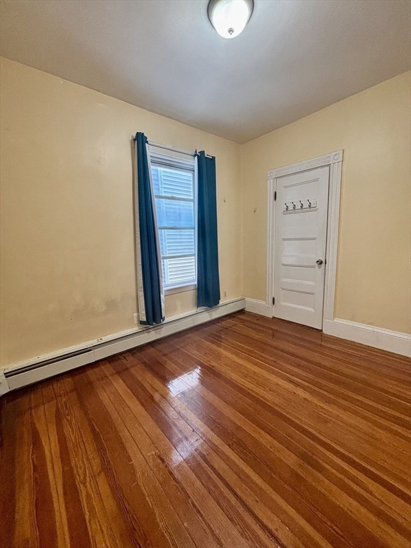 11 Raven Street, Unit 2 Boston, MA 02125 - Photo 6 of 10 a view of an empty room with wooden floor and a window