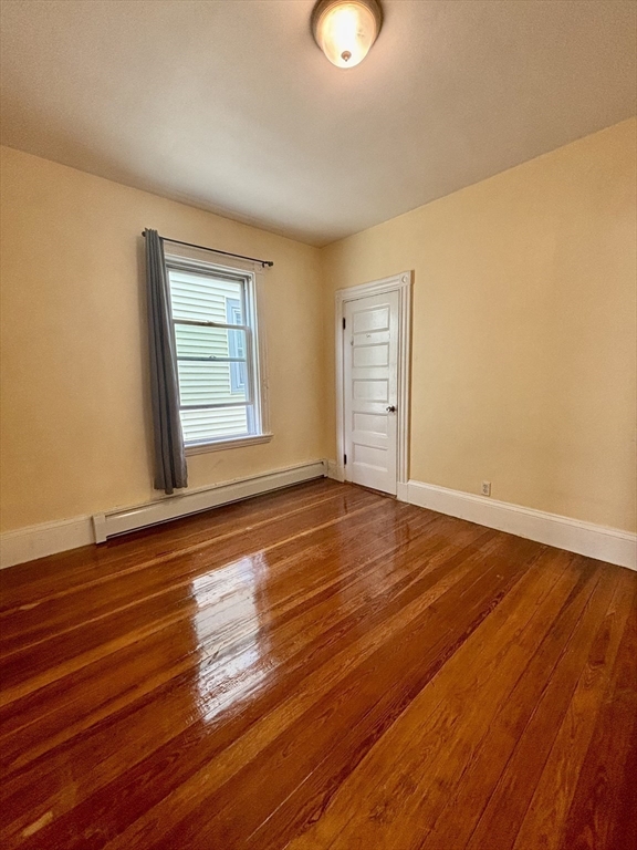 11 Raven Street, Unit 2 Boston, MA 02125 - Photo 7 of 10 an empty room with wooden floor and windows